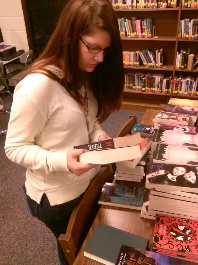 WE READ-- Freshman Bailey Evans chooses her free book from the supernatural genre during GCHS We Read Week.