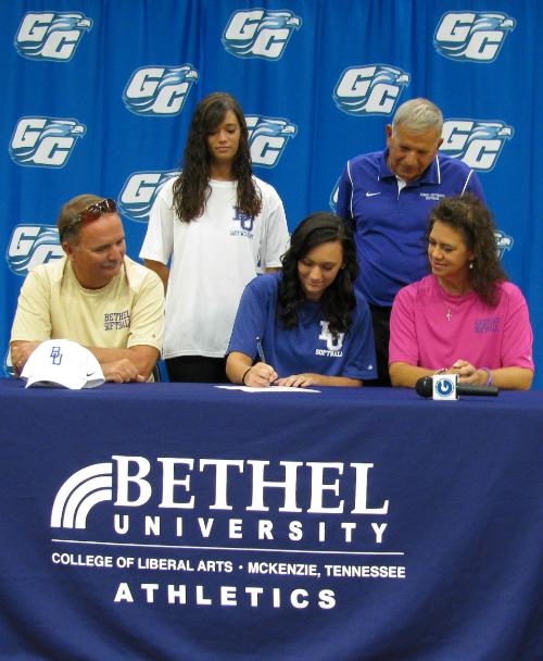 ON+THE+DOTTED+LINE--+Senior+Casey+Wade+signs+a+commitment+to+play+softball+for+Bethel+University+while+her+family+looks+on.