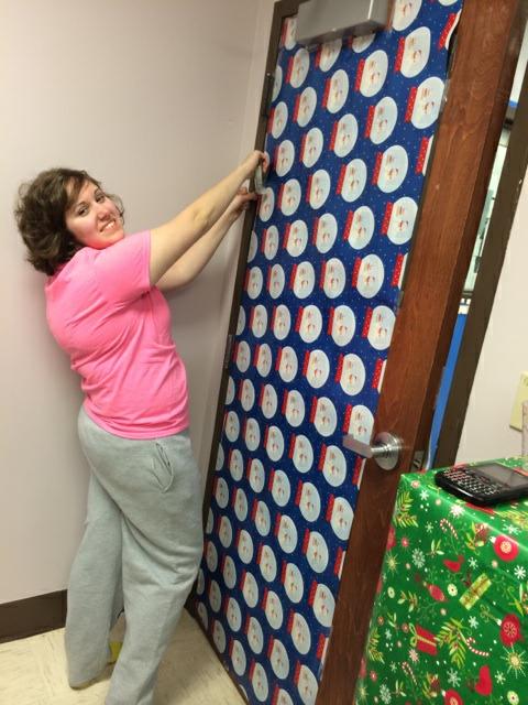 WRAPPING A SURPRISE-- Senior Nikki Padgett takes part in a good-humored holiday prank on orchestra director Cody Hein.