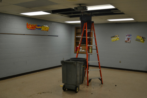 LEAK CONTINUES--  A custodian works to repair the damaged pipe that caused this morning's flood, as water continues to fall.