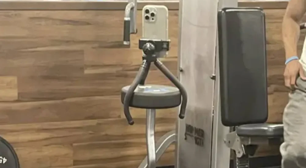 A gym entrance with emergency exit doors and fitness equipment nearby