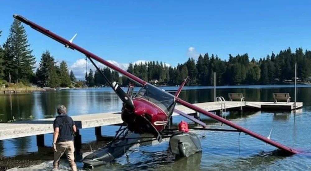 A floatplane after an emergency landing on Lake Ki with responders and a helper nearby